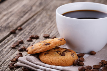 Tasty cookies and coffee cup on a wooden table.