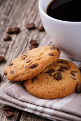 Tasty cookies and coffee cup on a wooden table.