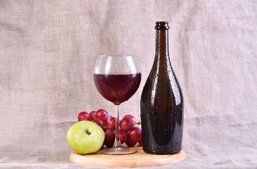 red wine in glass and bottle with grapes and apple