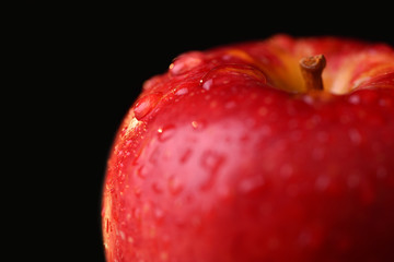 Red apple on dark background. Macro water drops
