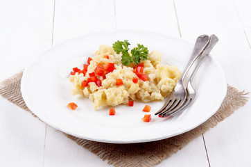Käsespätzle mit roten Paprikawürfeln und Petersilie