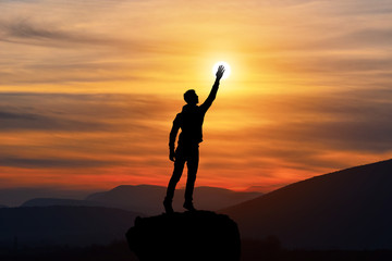 happy man with hand up on sunset background, silhouette man