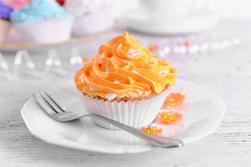 Delicious cupcakes on plate on table close-up