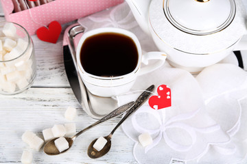 Heart shaped teabag tags, box and teapot on wooden background