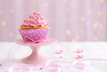 Sweet cupcake on table on light background