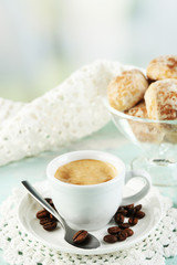 Cup of coffee and tasty cookie on color wooden background
