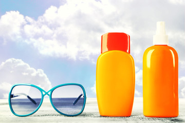 Bottles with suntan cream with sunglasses