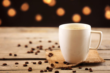 Cup of coffee on table on brown background