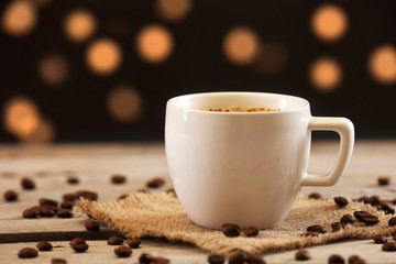 Cup of coffee on table on brown background