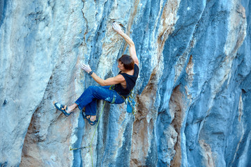 Rock climber climbing up a cliff
