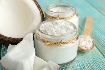 Fresh coconut oil in glassware and wooden spoon