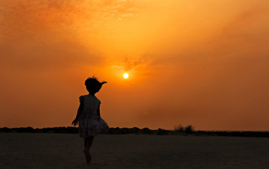 Girl running towards the sun