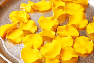 Rose petals in bowl on wooden background