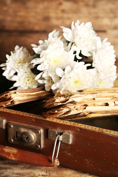 Old wooden suitcase with old books and flowers