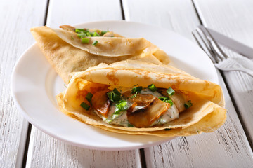Pancakes with creamy mushrooms and greens in plate