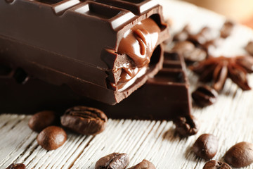 Stuffed chocolate with coffee beans on wooden table, closeup
