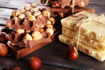 Set of chocolate with hazelnut on wooden table, closeup