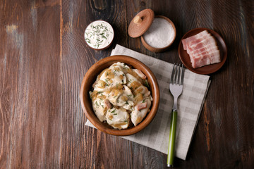 Fried dumplings with onion and bacon in frying pan,