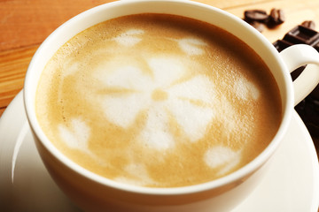 Cup of coffee latte art on wooden table, closeup
