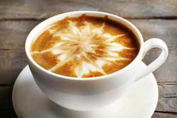 Cup of coffee latte art on wooden table, closeup