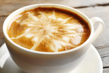 Cup of coffee latte art on wooden table, closeup