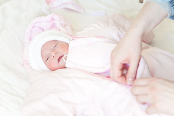 Fototapeta na wymiar Dressing a newborn baby