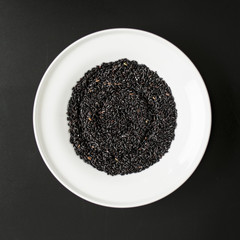 Black rice heap in ceramic dish top view close up isolated on