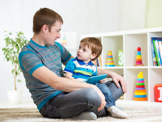 dad and son kid play with tablet computer indoors © Oksana Kuzmina
