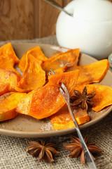 Plate with baked pumpkin, sprinkled with cinnamon and sugar.