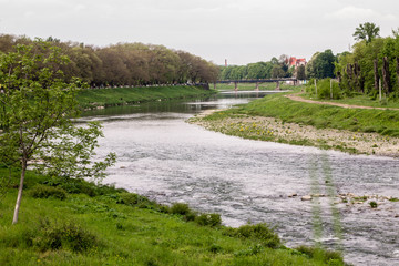 river flow in town and green grass on banks