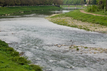 river flow in town and green grass on banks