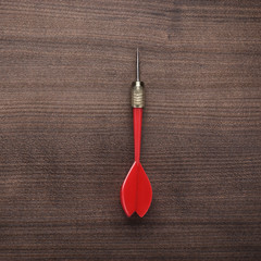 red dart on wooden background