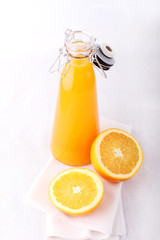 orange and a bottle of orange juice, white background