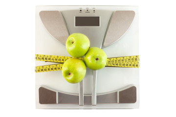 Scale with a measuring tape and apple