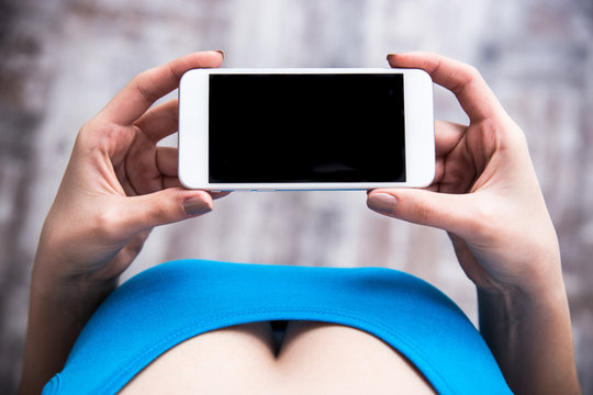Closeup image of female hands holding smartphone