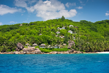 Obraz premium View of Seychelles coastline with houses in the forest