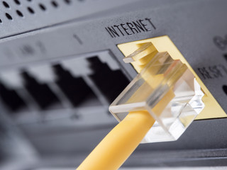 Network yellow cable connected to a router or modem - obrazy, fototapety, plakaty