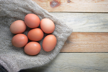 Some eggs on a sackcloth on a wooden table.