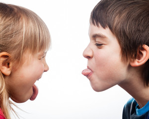 Siblings sticking out tongues