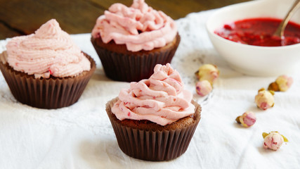 Cupcakes with cream cheese cream with raspberry and dry roses