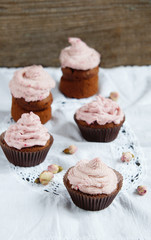 Cupcakes with cream cheese cream with raspberry and dry roses