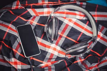 Phone and headphones on a shirt, listening to music