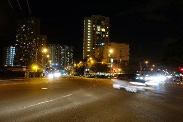 Fototapeta na wymiar Cars race along Kapiolani Boulevard at Night