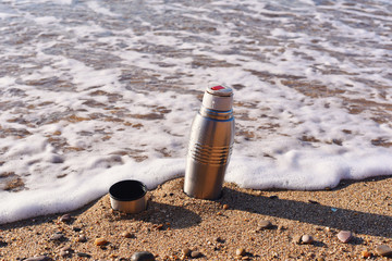 Heat protection-thermos coffee tea cup on the beach