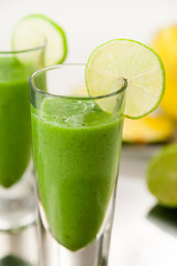 Green Smoothie with Fruits in Background
