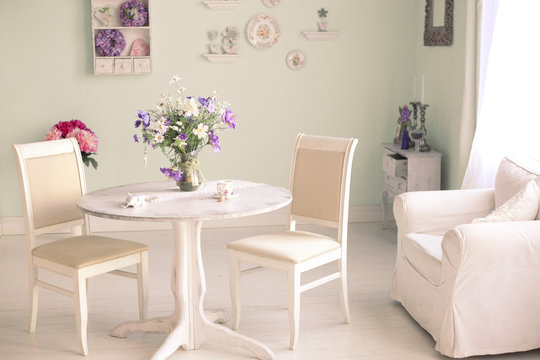 shabby chic dining room interior with flowers decorative plates