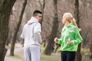 Meeting of two young people who jogging in a park