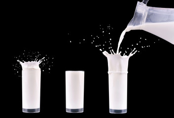 Milk is pouring from jug bottle into the glass with splash