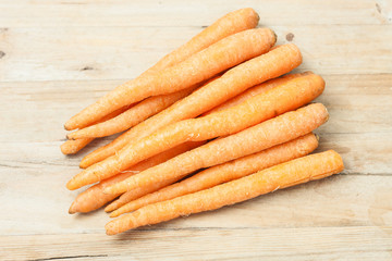a bunch of fresh picked carrots on wooden background