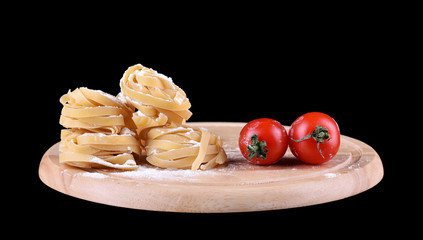 Pasta spaghetti noodles with tomatoes on wooden plate